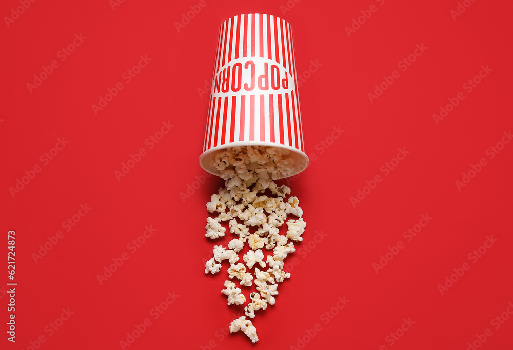 Bucket with tasty popcorn on red background