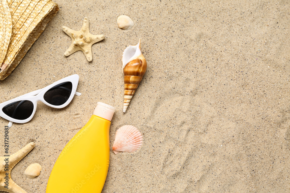 Sunglasses with wicker bag, starfishes and bottle of sunscreen cream on sand