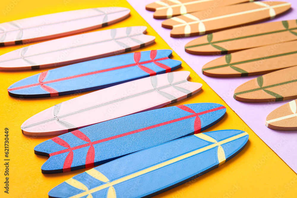 Many different mini surfboards on color background