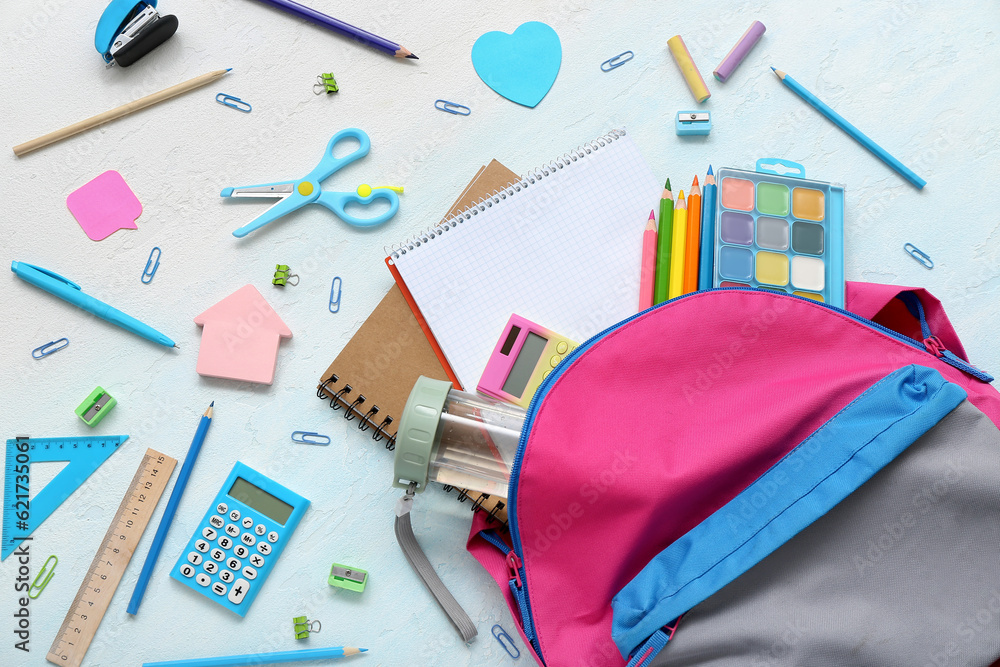 Backpack with blank notebook and different stationery on color background