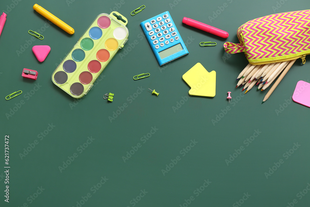 Calculator with different stationery on green chalkboard