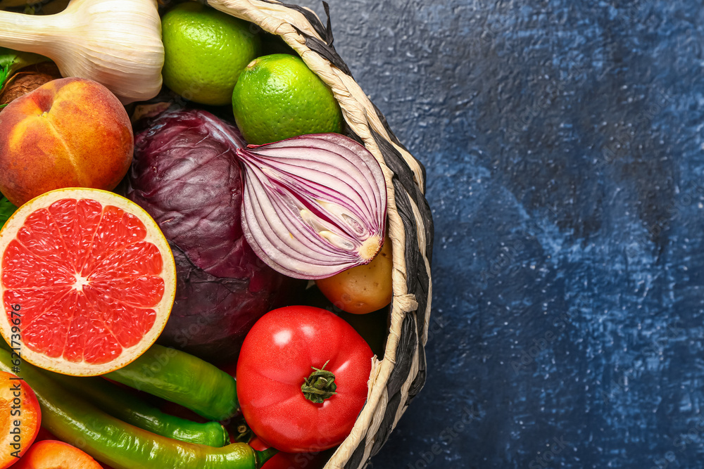 Wicker bowl with different fresh fruits and vegetables on blue background, closeup