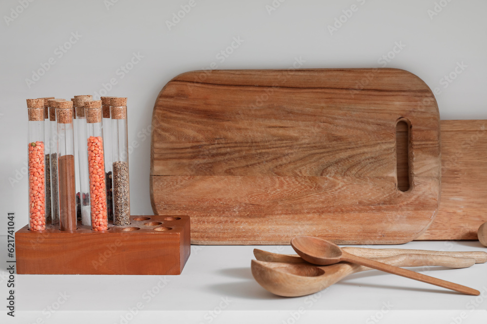 Wooden spoons with cutting boards and spices on counter in kitchen, closeup