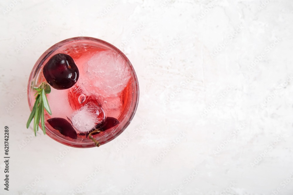 Glass of tasty cherry lemonade with rosemary on white background