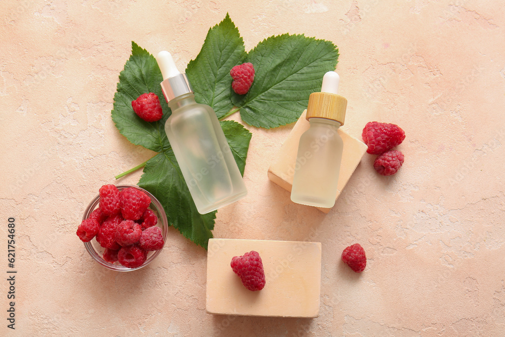 Decorative podiums with bottles of cosmetic raspberry oil on pink background