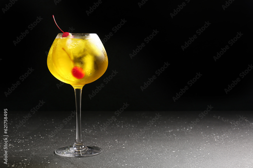 Glass of tasty cocktail with maraschino cherries on table