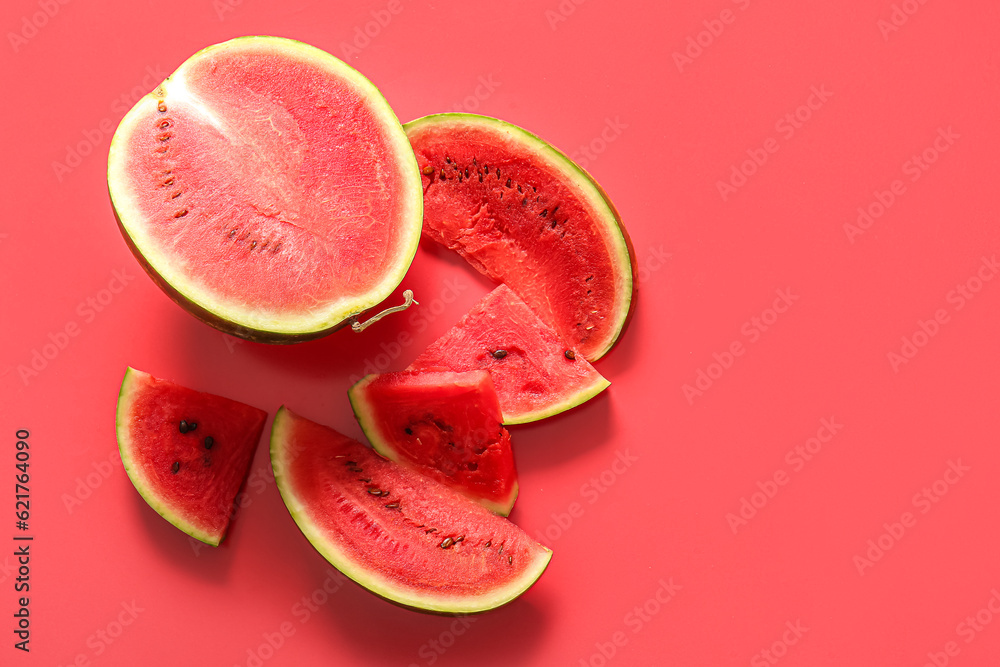 Half of fresh watermelon with pieces on red background