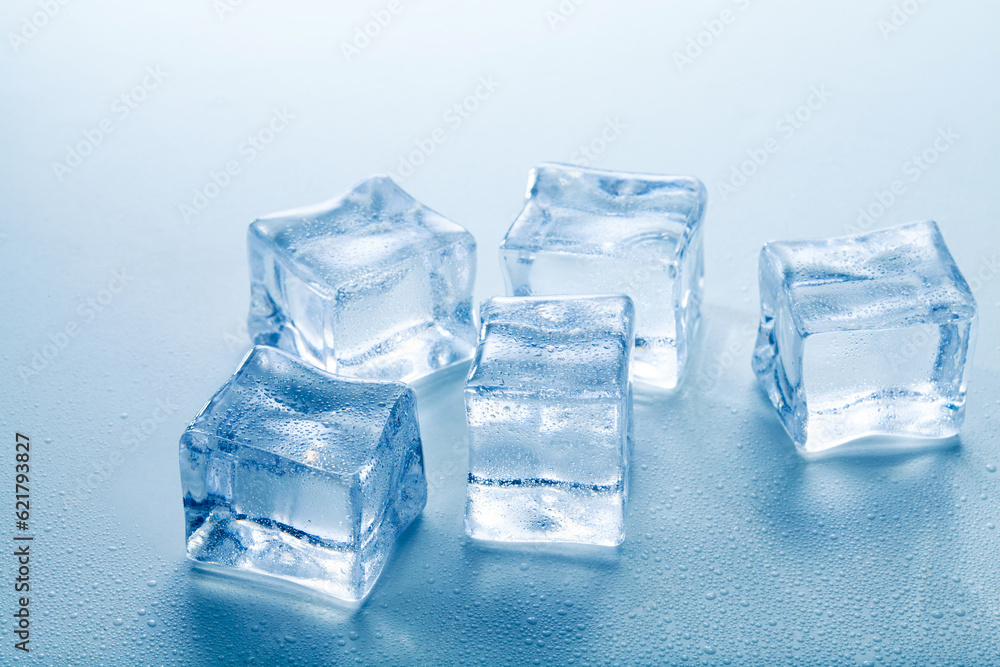 clear ice cubes with water drops on blue background.