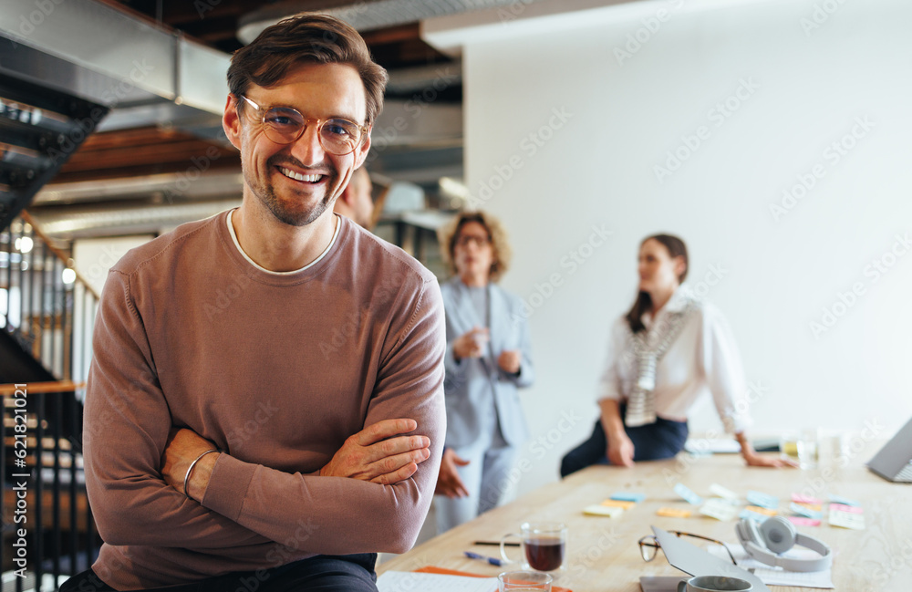 Successful business man sitting in a boardroom with his team