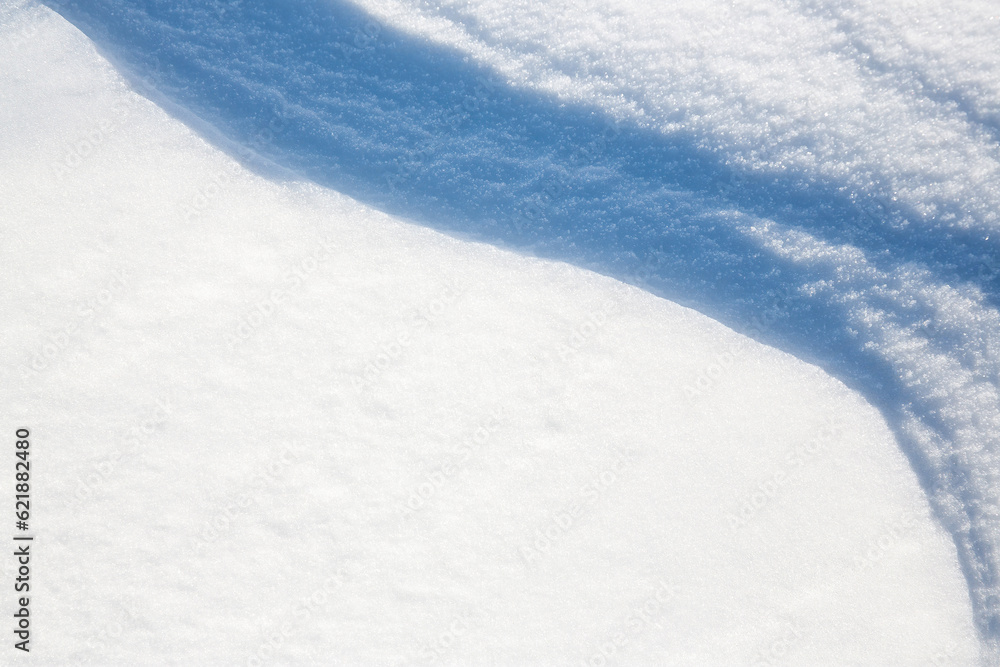 Beautiful winter background with snowy ground. Natural snow texture. Wind sculpted patterns on snow 