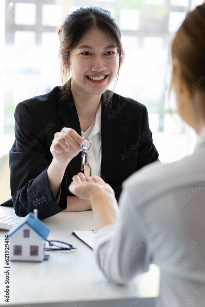 Businesswoman real estate agent hands over the house keys to a homebuyer after the purchase agreemen