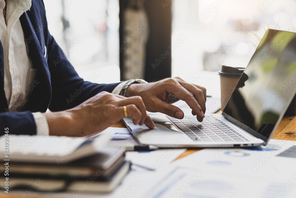 Businessman working on documents on the desk, data analysis of financial figures on laptop and busin