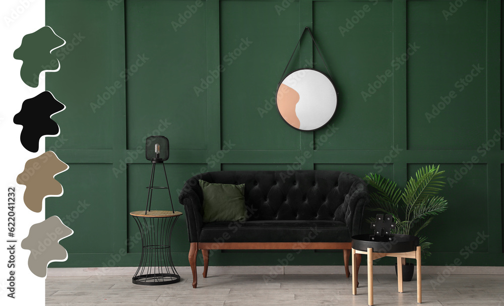 Interior of stylish room with round mirror, velvet sofa and tables near green wall. Different color 