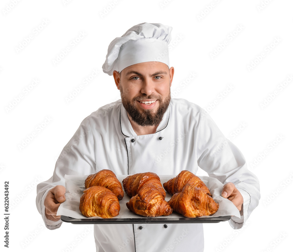 Male baker with tray of tasty croissants on white background