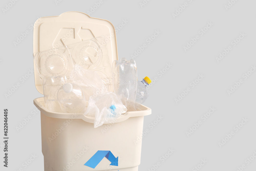 Container for garbage with plastic on light background. Recycling concept