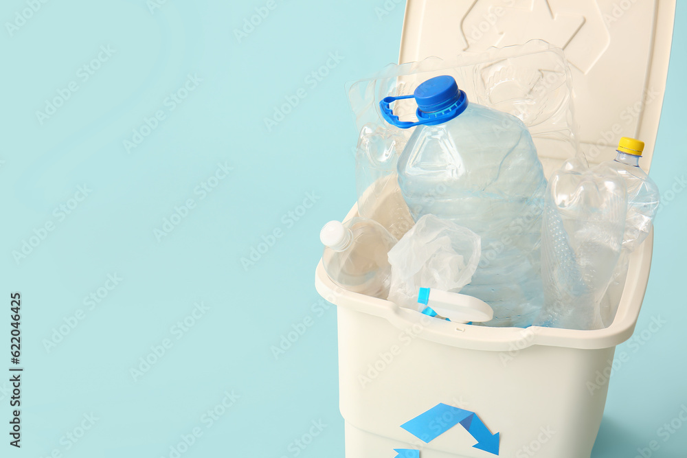 Container for garbage with plastic on light blue background. Recycling concept