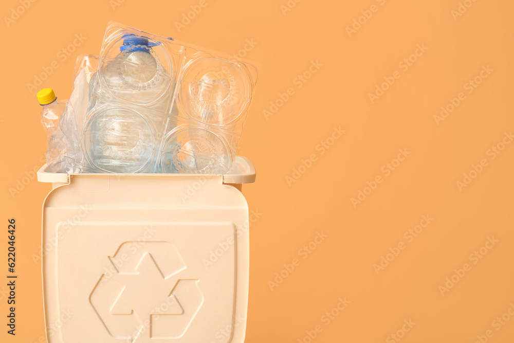 Container for garbage with plastic on beige background. Recycling concept