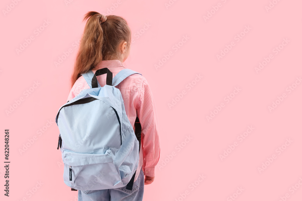 Little schoolgirl with backpack on pink background, back view