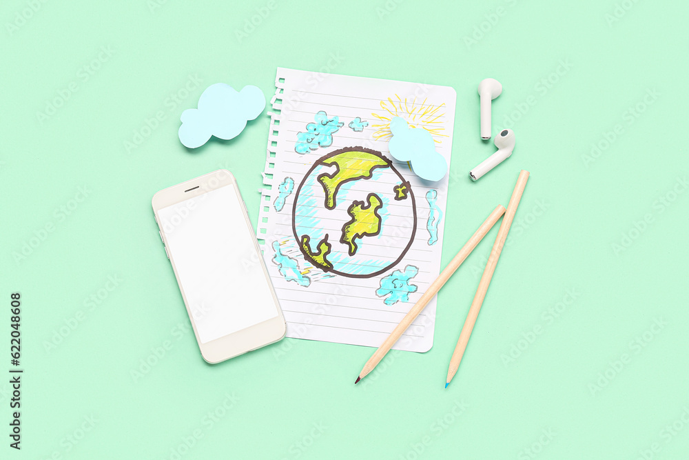 Mobile phone, earphones and paper with drawings on green background. Weather forecast concept