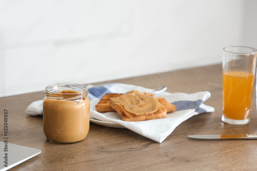 Tasty toasts with nut butter on table in kitchen, closeup