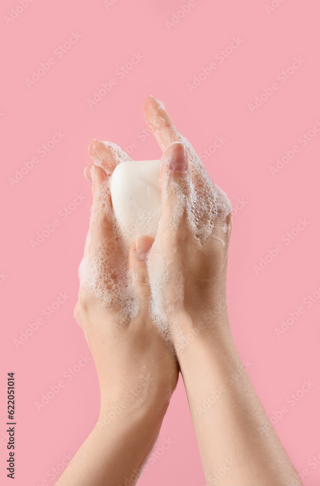 Hands with soap on pink background