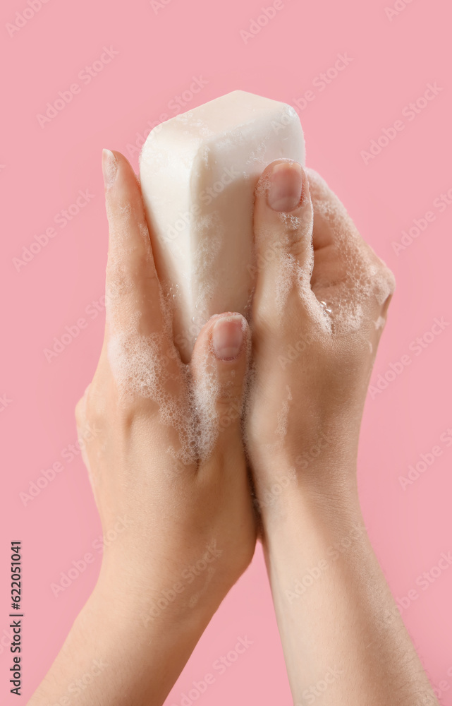 Hands with soap on pink background