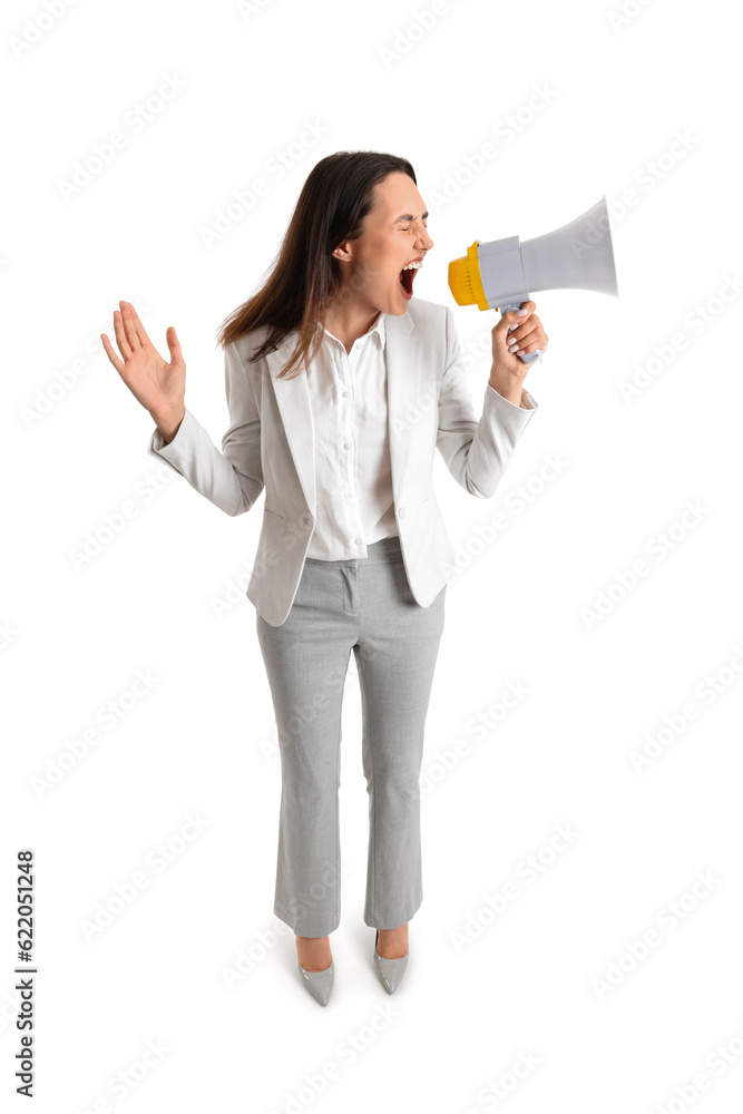 Young businesswoman in stylish suit shouting into megaphone on white background