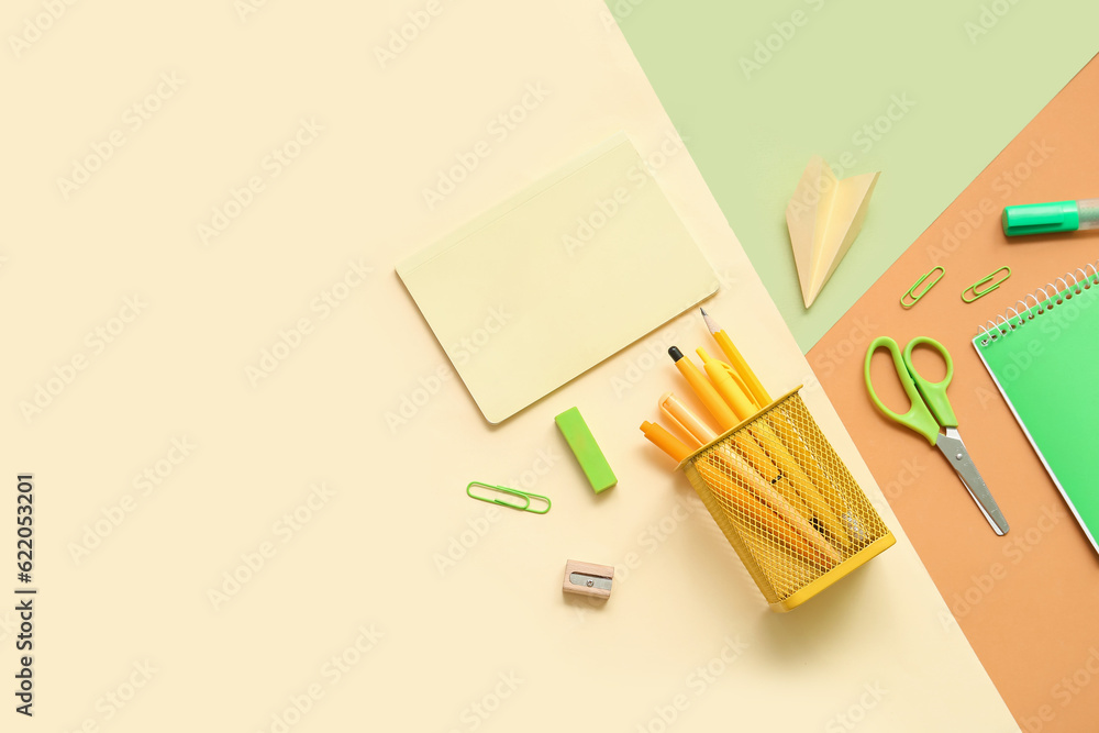 Composition with notebooks and different school stationery on color background