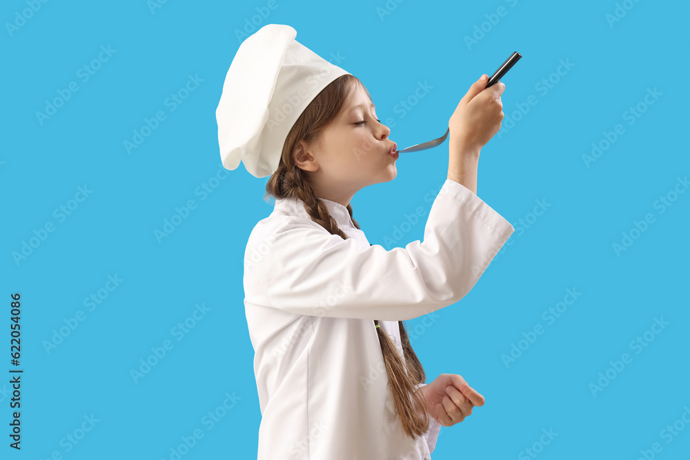 Little chef with spoon on blue background