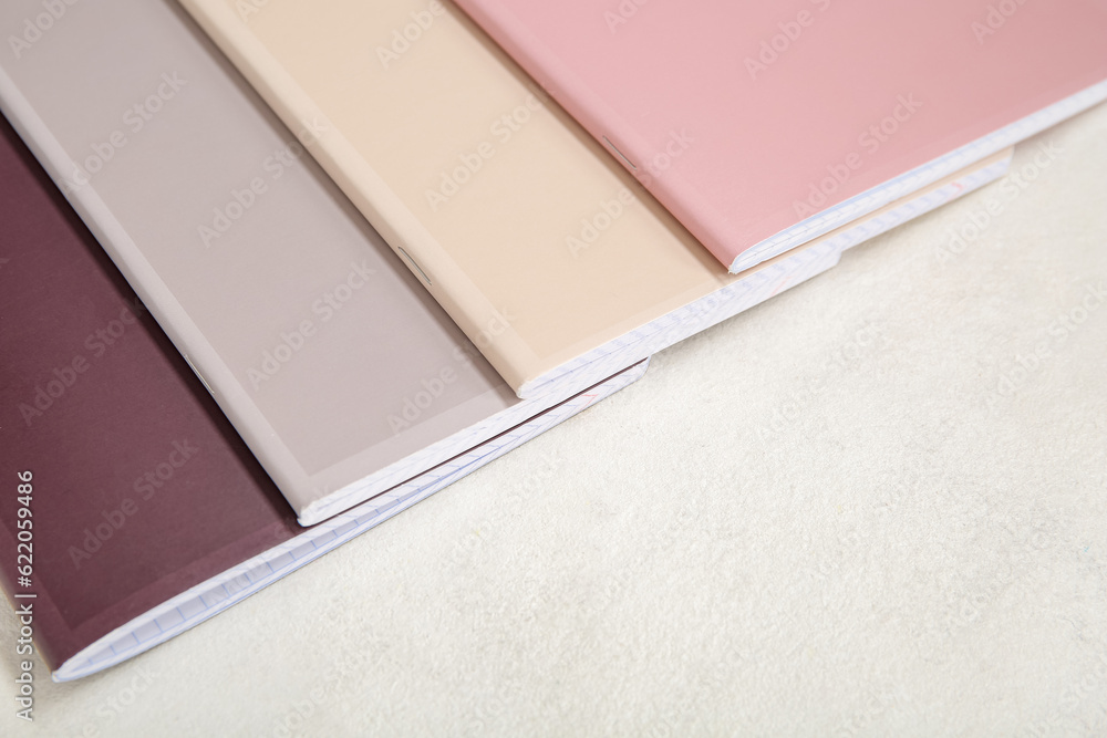 Different colorful notebooks on white background