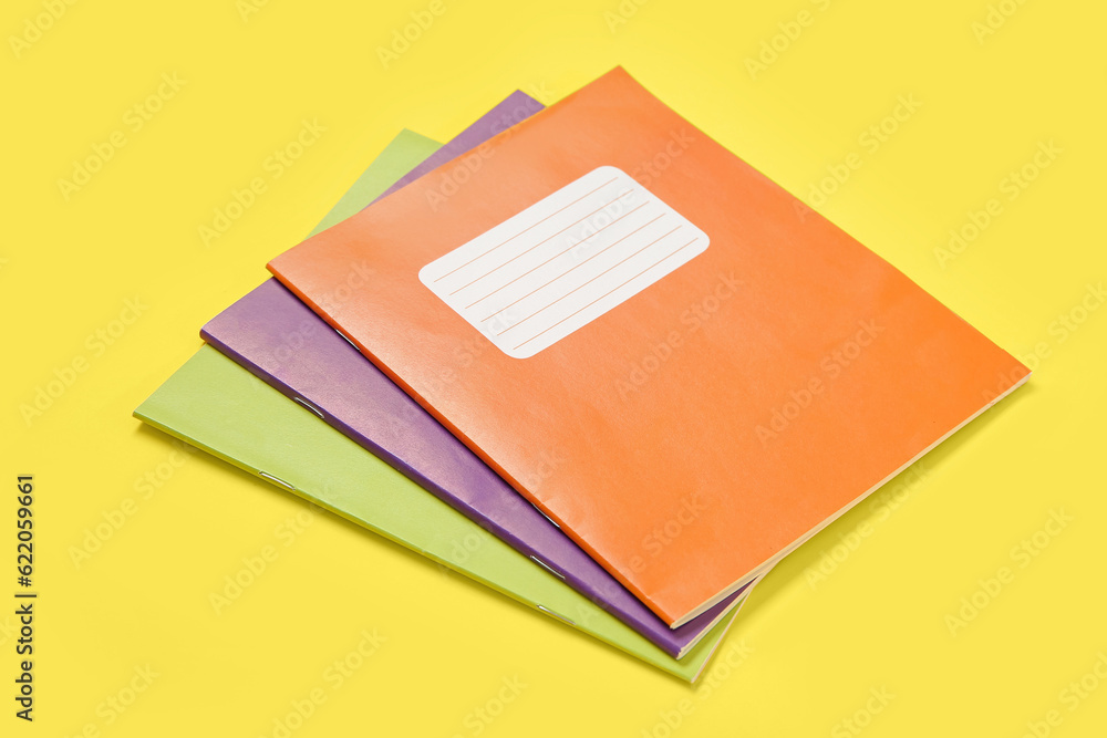 Different colorful notebooks on yellow background