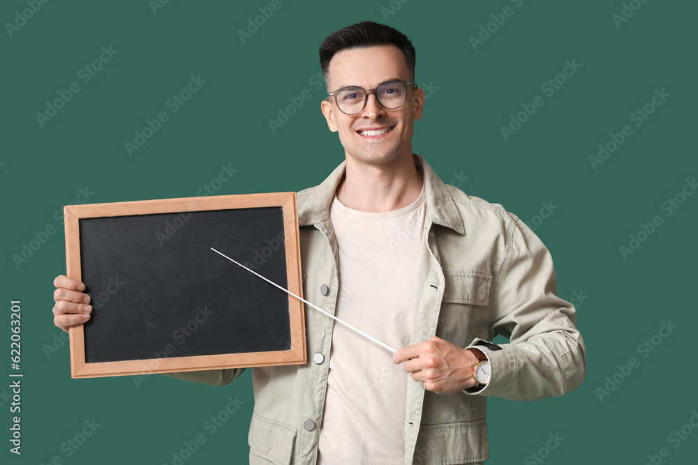 Male teacher with pointer and chalkboard on green background