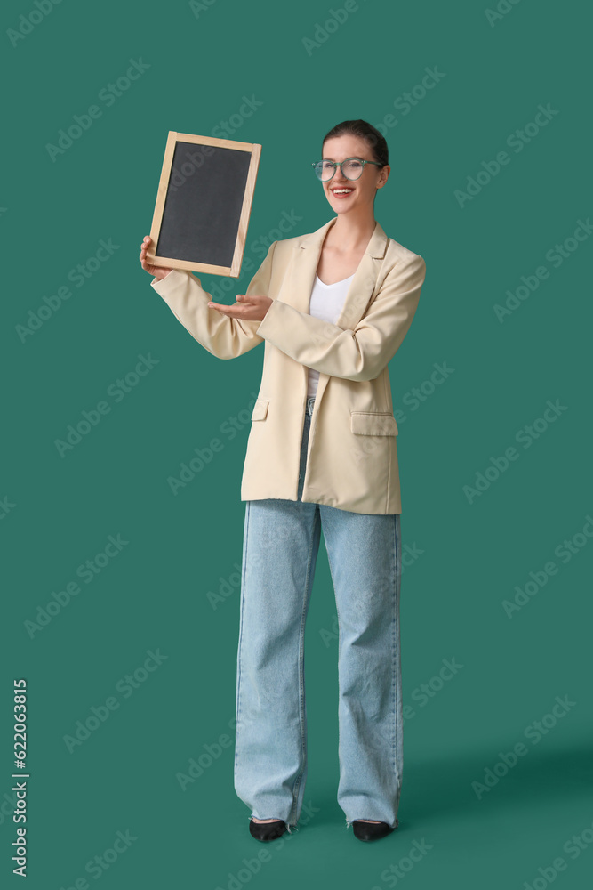 Female teacher with chalkboard on green background