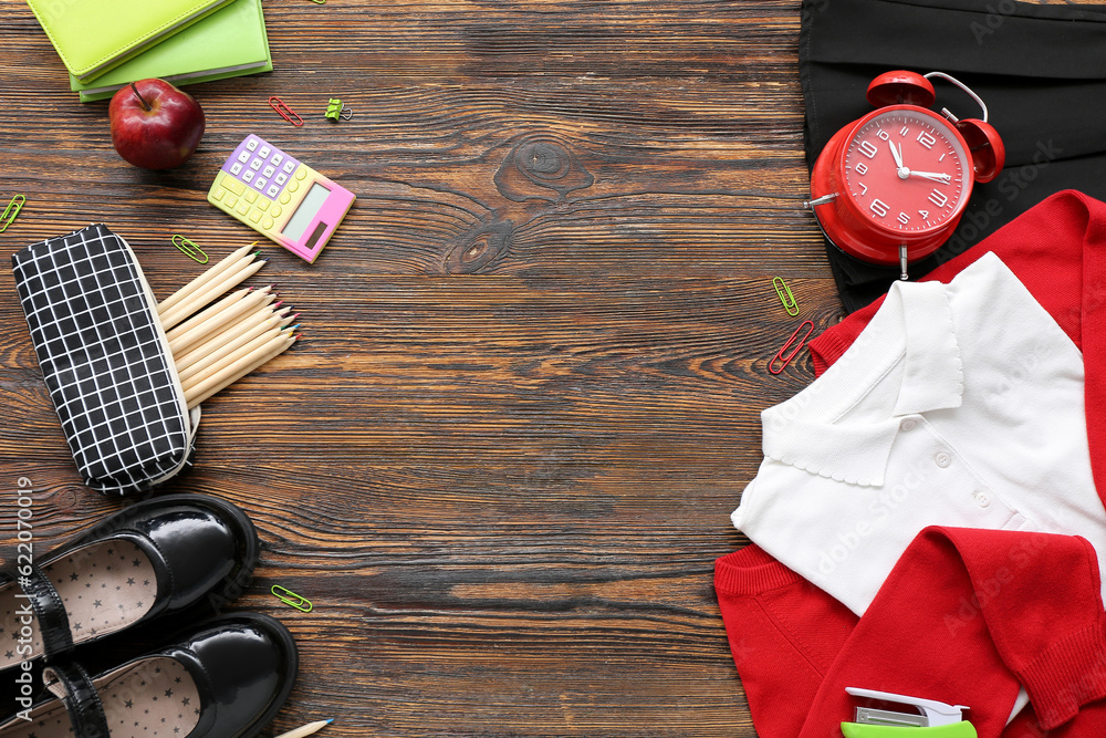 Different stationery with stylish school uniform on wooden background