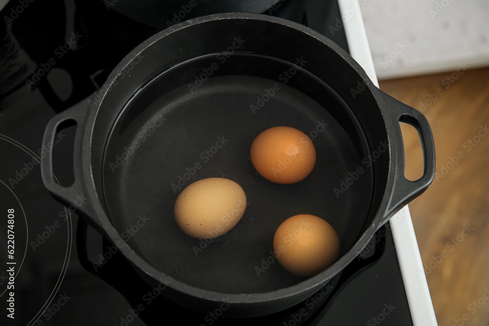 Chicken eggs boiling in cooking pot, closeup