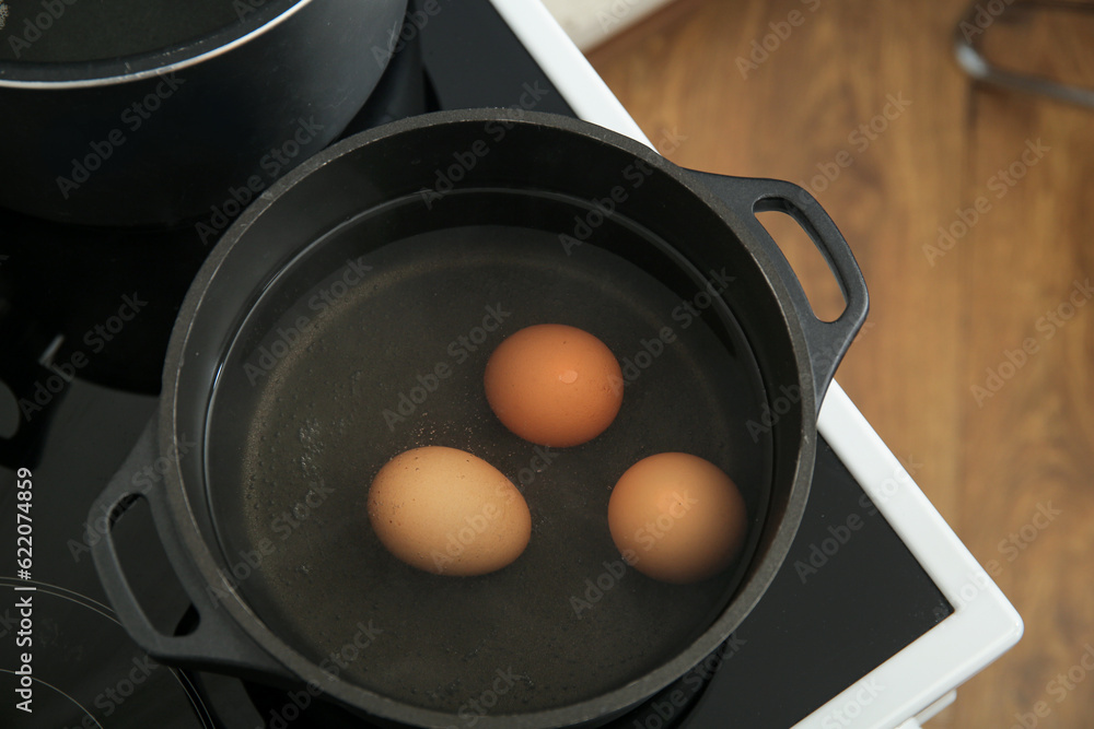 Chicken eggs boiling in cooking pot, closeup