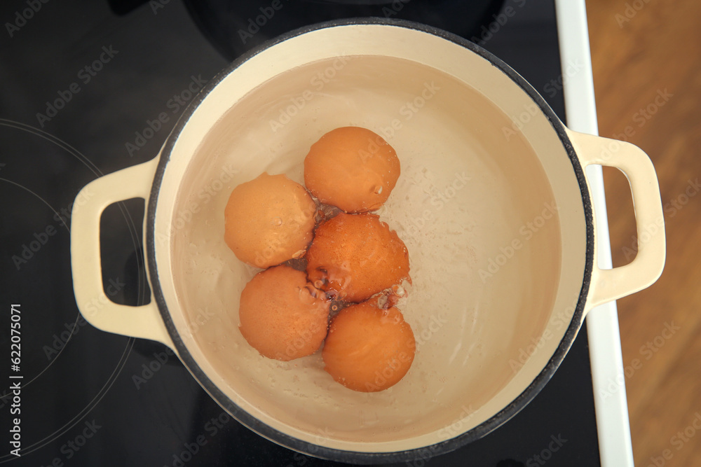 Chicken eggs boiling in cooking pot, closeup