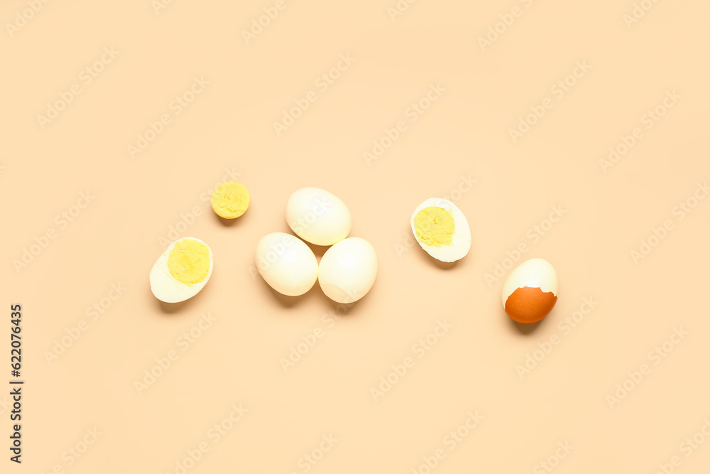 Tasty boiled eggs with halves on orange background