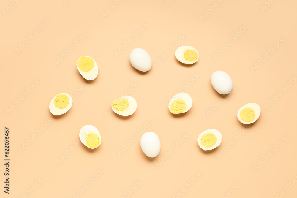 Tasty boiled eggs with halves on orange background