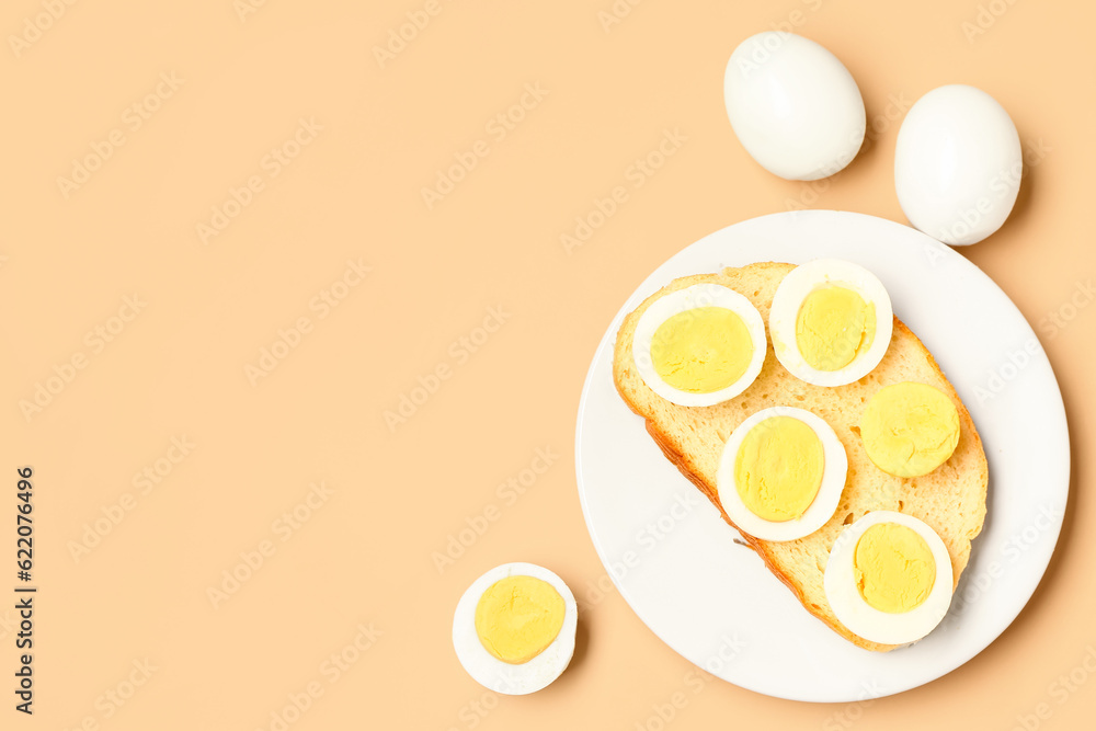 Plate of toast with boiled eggs on orange background