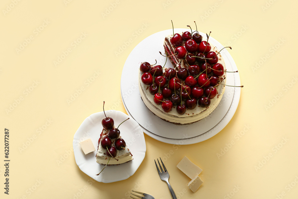 Plates with tasty cherry cake on yellow background