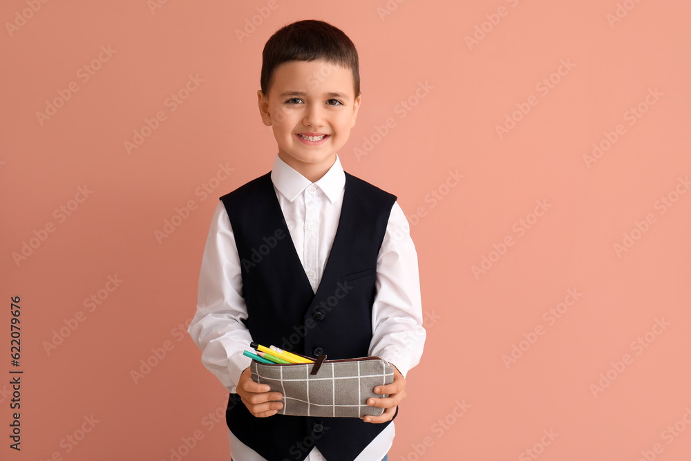 Cute little schoolboy with pencil case on color background