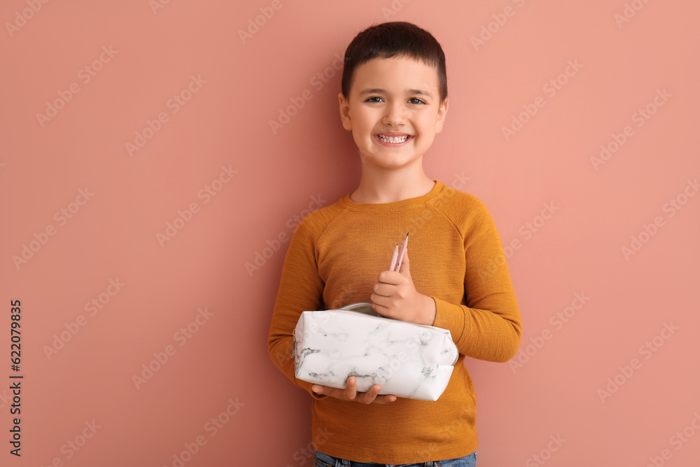 Cute little boy with pencil case on color background