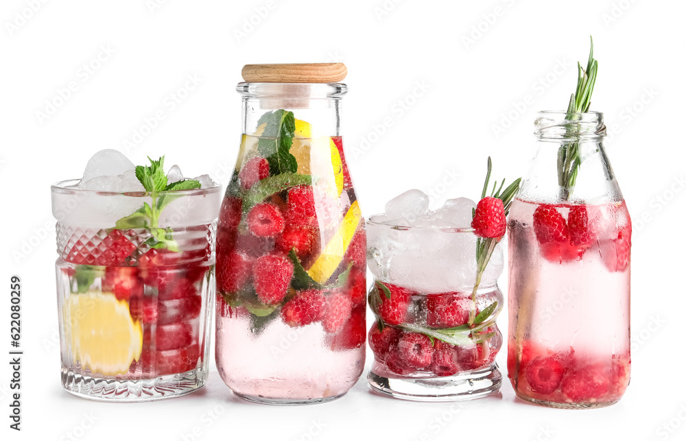 Glasses and bottles of fresh raspberry lemonade on white background