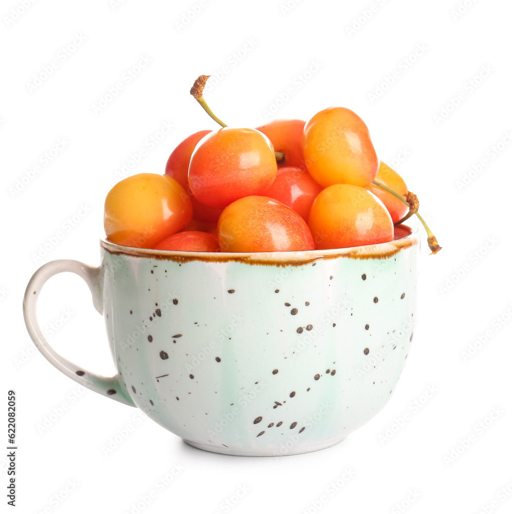 Cup with sweet yellow cherries on white background