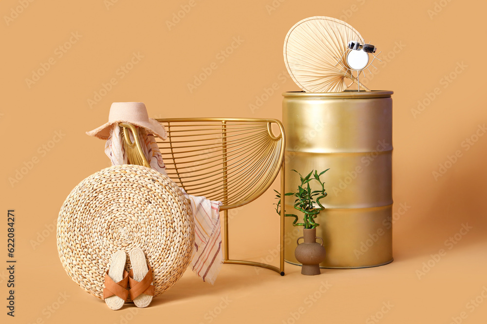 Chair with barrel and beach accessories on beige background. Travel concept