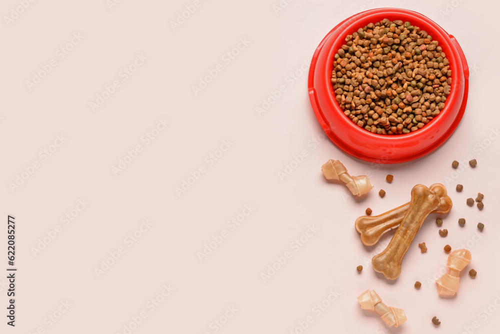 Different dog treats and dry food on light background