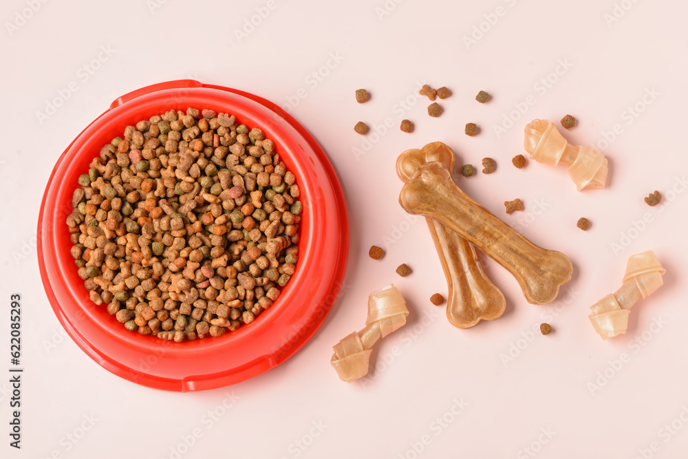 Different dog treats and dry food on light background