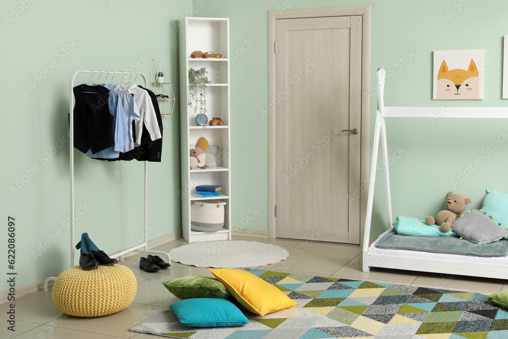 Stylish interior of childrens room with comfortable bed and school uniform