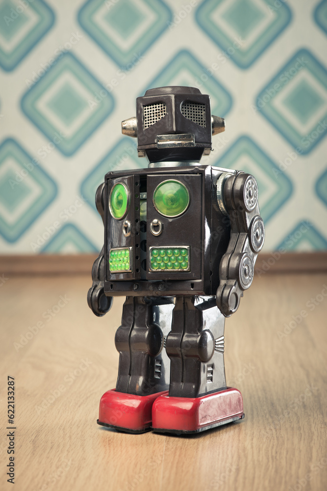 Vintage funny tin toy robot on vintage wallpaper background.